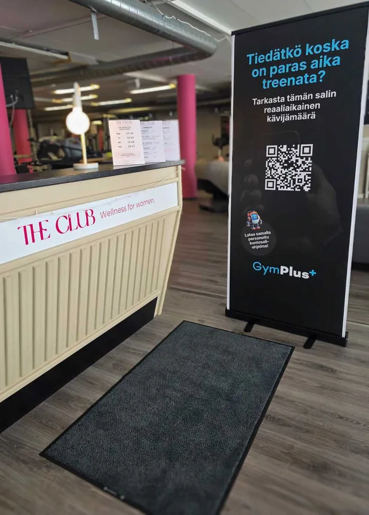 GymPlus besöksräknare på en roll-up bredvid receptionsdisken på The Club Wellness